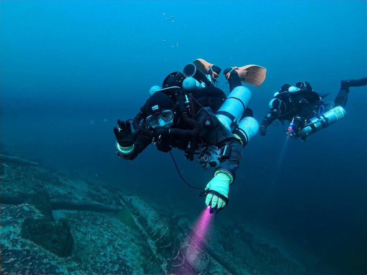 Zwei Taucher mit JJ-CCR Rebreather über Grund, mit Lampen